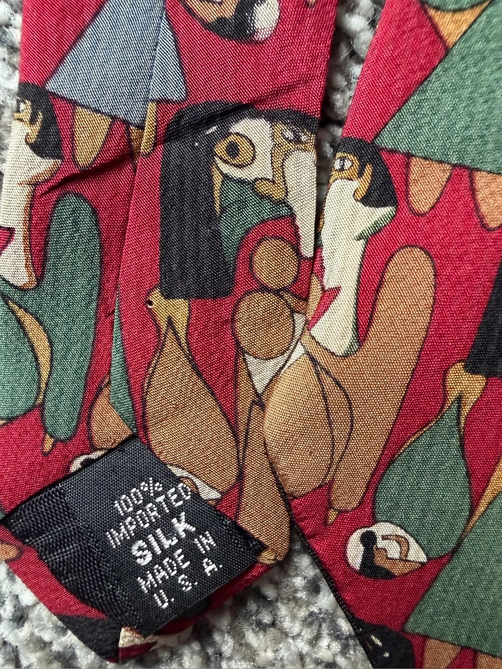 silk tie with abstract geometric pattern in red, green, and brown